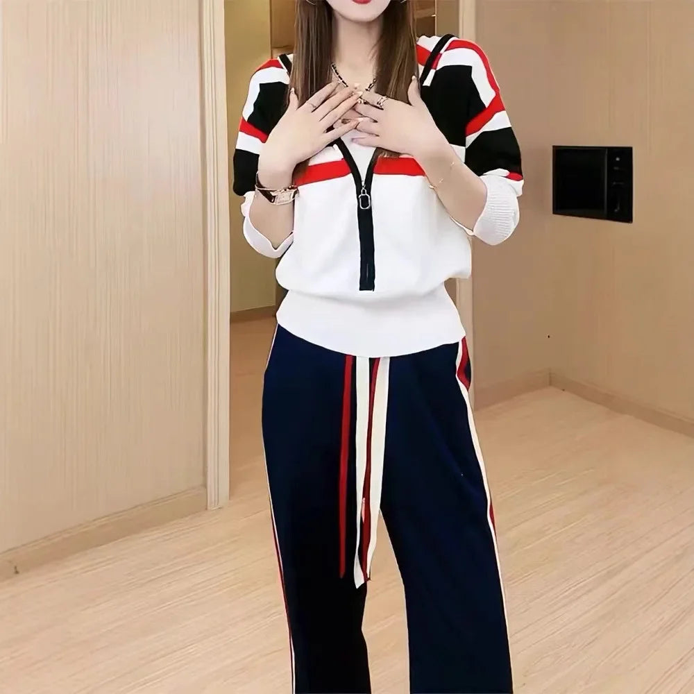 Person wearing a white and black outfit with red accents in a room.