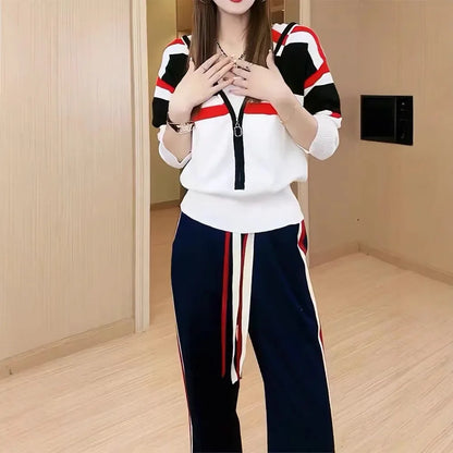 Person wearing a white and black outfit with red accents in a room.