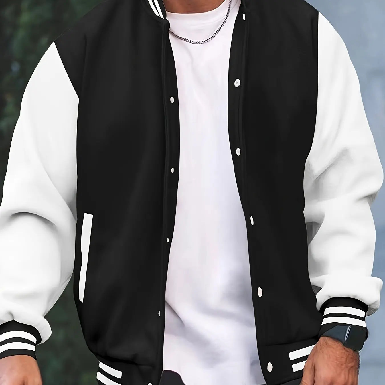 Black and white varsity jacket worn by a person with a blurred background