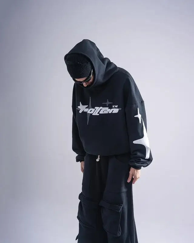 Person wearing a black hoodie with a logo on a gray background