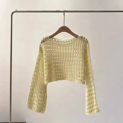 Yellow crochet sweater on a hanger against a plain background