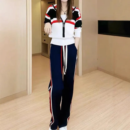 Person wearing a colorful tracksuit in a room with wooden flooring and a neutral wall.