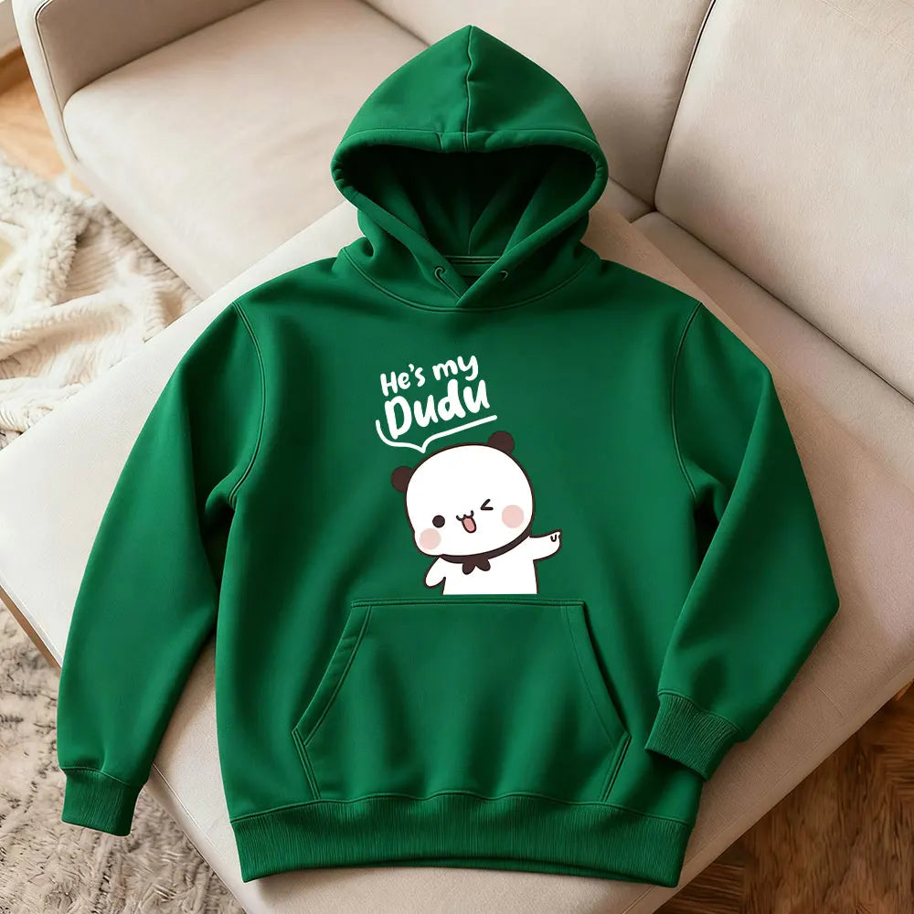 Green hoodie with cartoon design and text on a beige chair