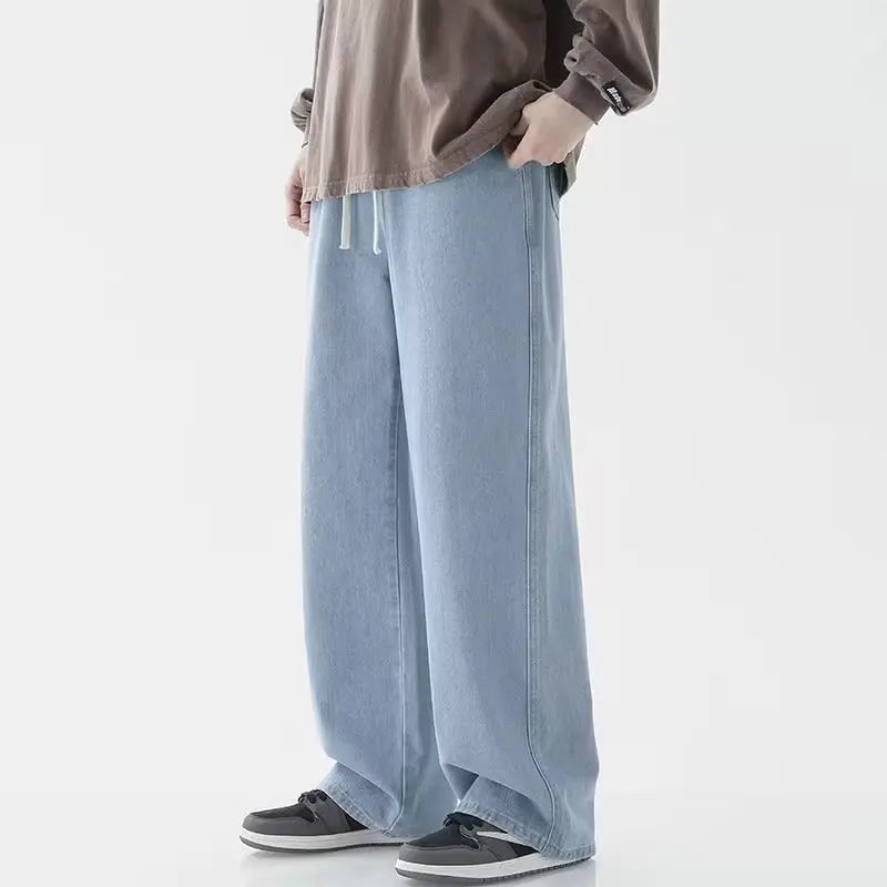 Person wearing light blue wide-leg pants and a brown jacket on a white background