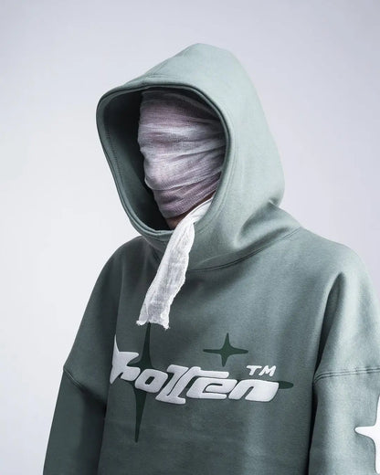 Person wearing a green hoodie with a brand logo on a light gray background