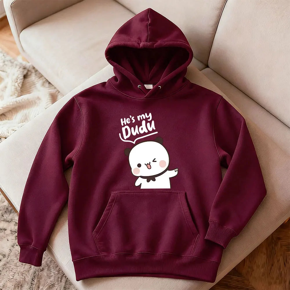 Maroon hoodie with cartoon character and text on a beige couch
