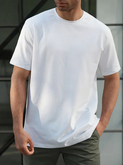 Person wearing a plain white t-shirt with a neutral background