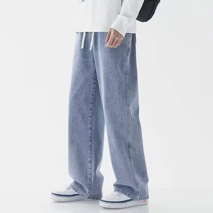 Person wearing light blue jeans and white sneakers on a white background