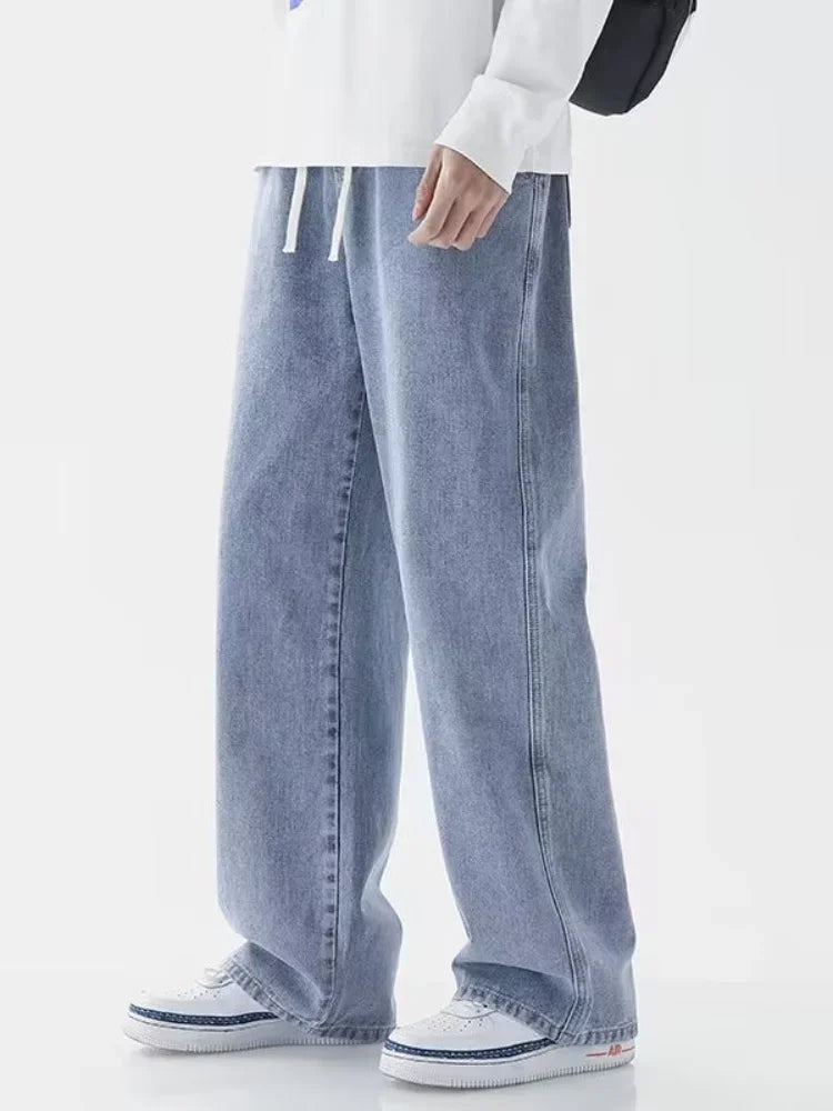 Person wearing light blue jeans and white sneakers on a white background
