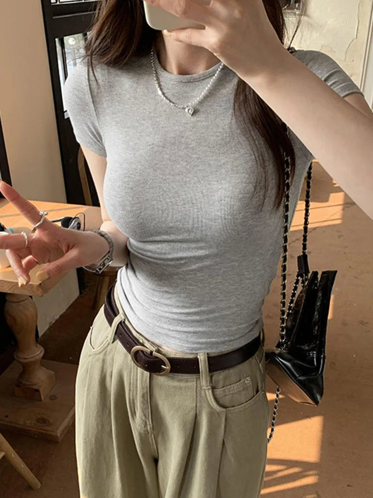 Person wearing a gray t-shirt and beige pants indoors.