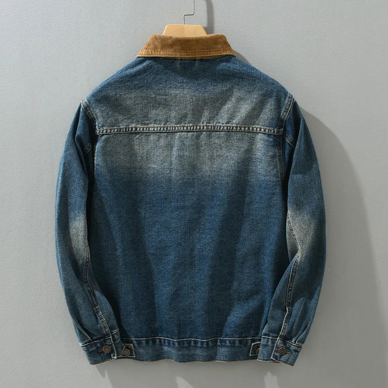 Blue denim jacket with brown collar on a gray background