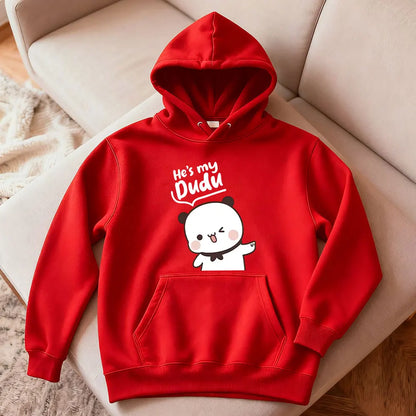 Red hoodie with cartoon design and text on a beige couch