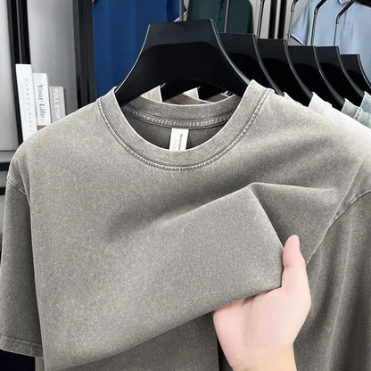 Gray t-shirt on a hanger with a hand touching it, set against a background of more shirts on hangers.
