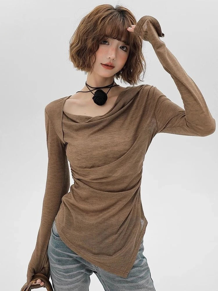 Woman wearing a brown long-sleeve top and light blue jeans on a white background
