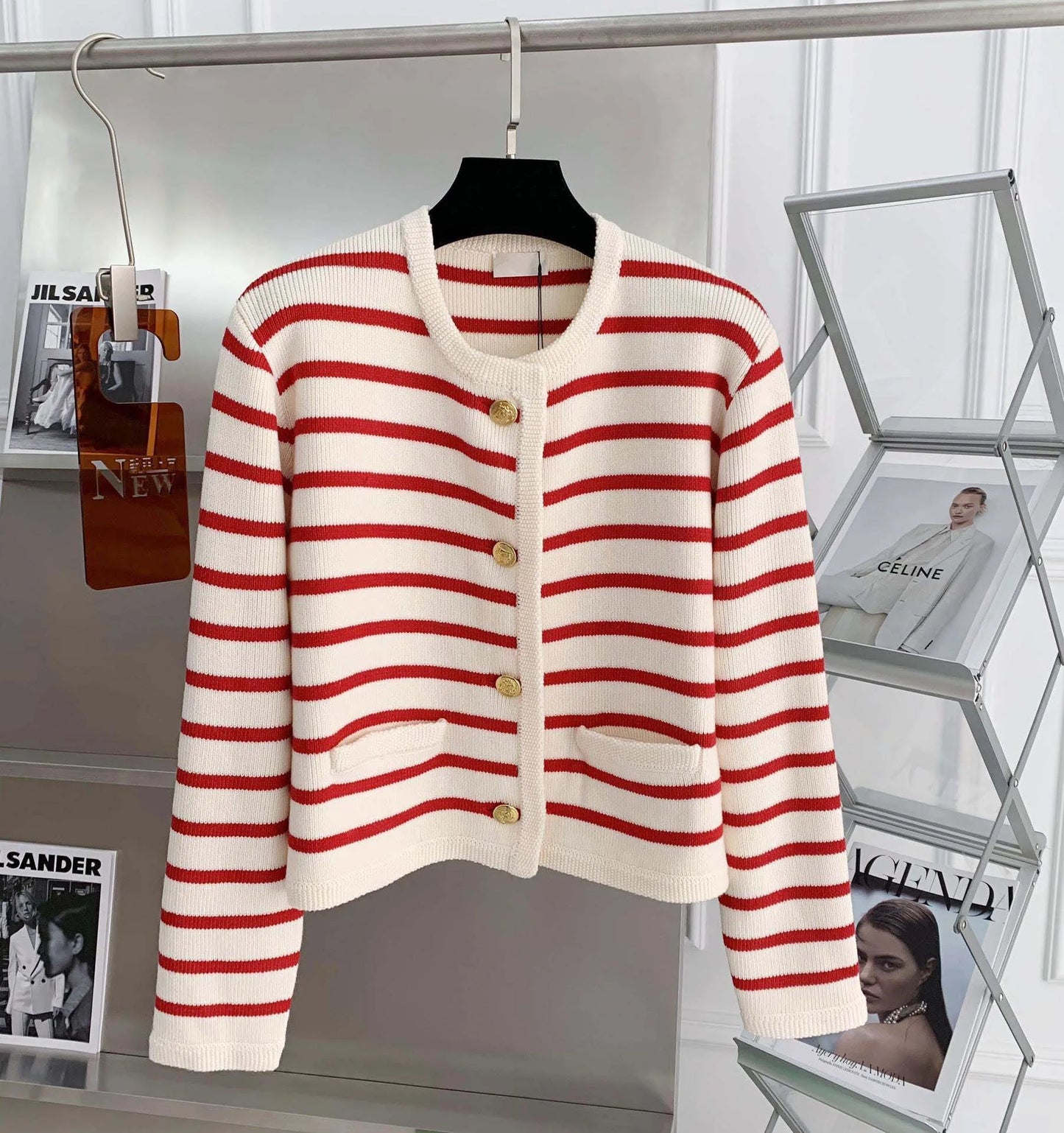 Red and white striped cardigan on a mannequin against a magazine rack background