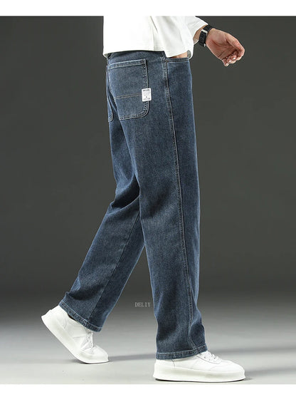 Person wearing blue jeans and white sneakers on a gray background