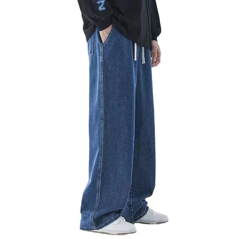 Person wearing blue jeans and a black jacket on a white background