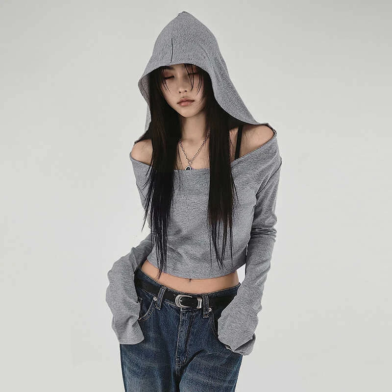 Person wearing a gray hoodie and jeans on a plain background
