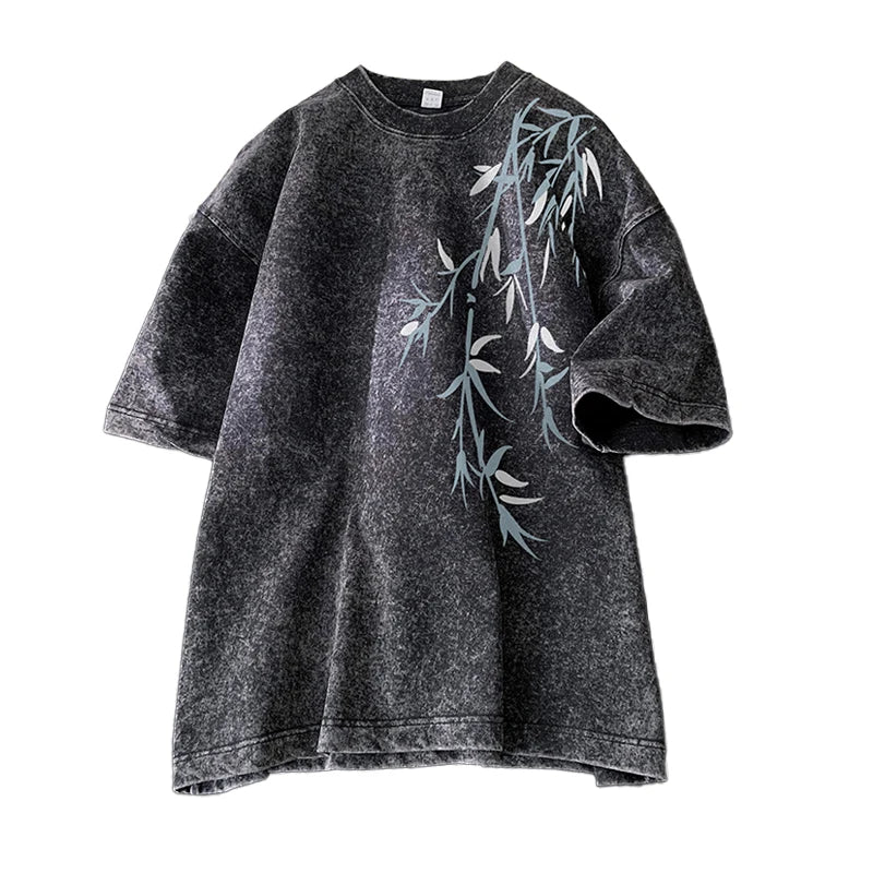Black t-shirt with green leaf design on a white background