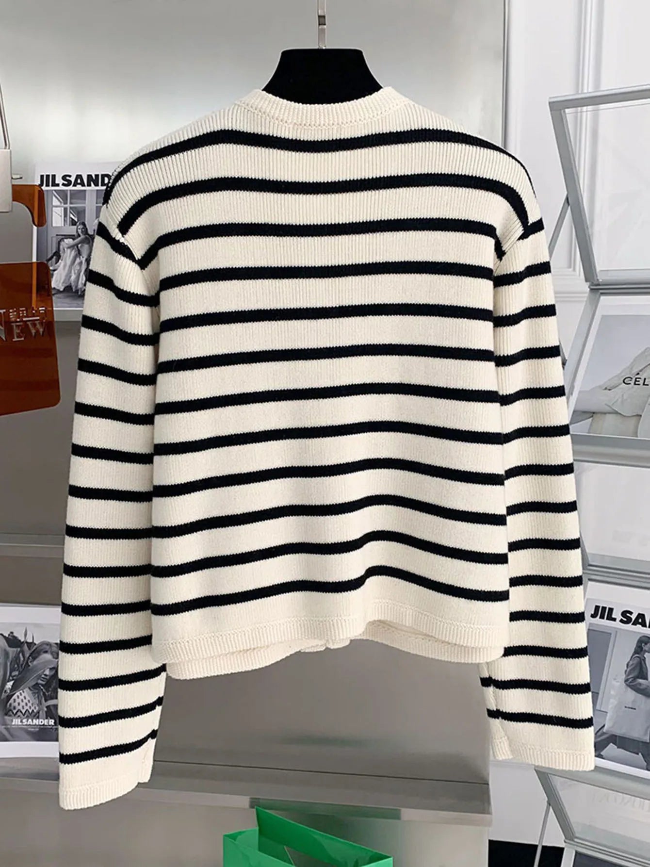Black and white striped sweater on a mannequin against a blurred indoor background