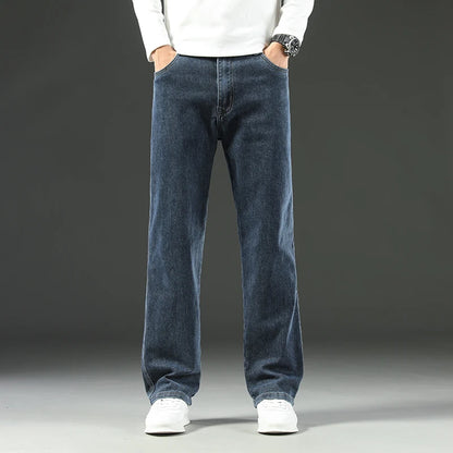 Person wearing blue jeans and a white shirt on a gray background