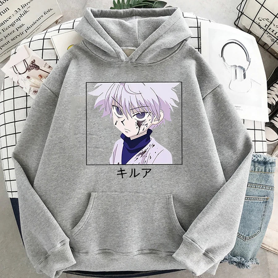Gray hoodie with anime character print on a surface with books and jeans.