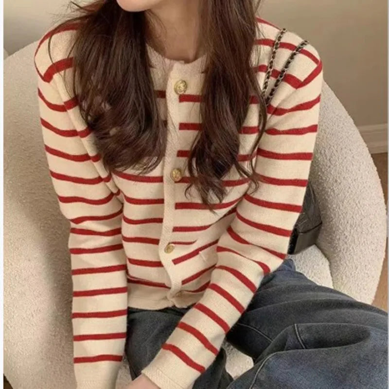Person wearing a red and white striped cardigan sitting on a couch.