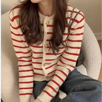 Person wearing a red and white striped cardigan sitting on a couch.