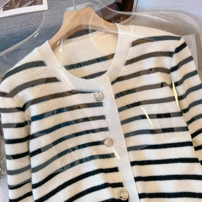 Striped cardigan with buttons on a hanger against a clear background