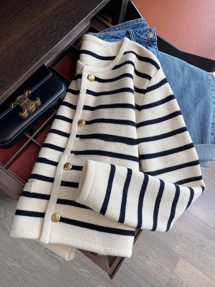 Striped cardigan with gold buttons on a wooden surface