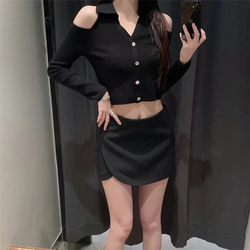 Person wearing a black outfit with a high-low skirt in front of a mirror.