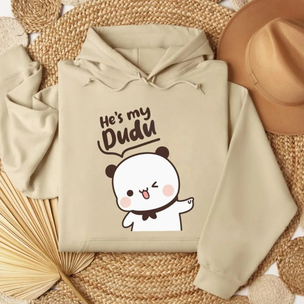 Beige hoodie with cartoon design and text on a woven surface