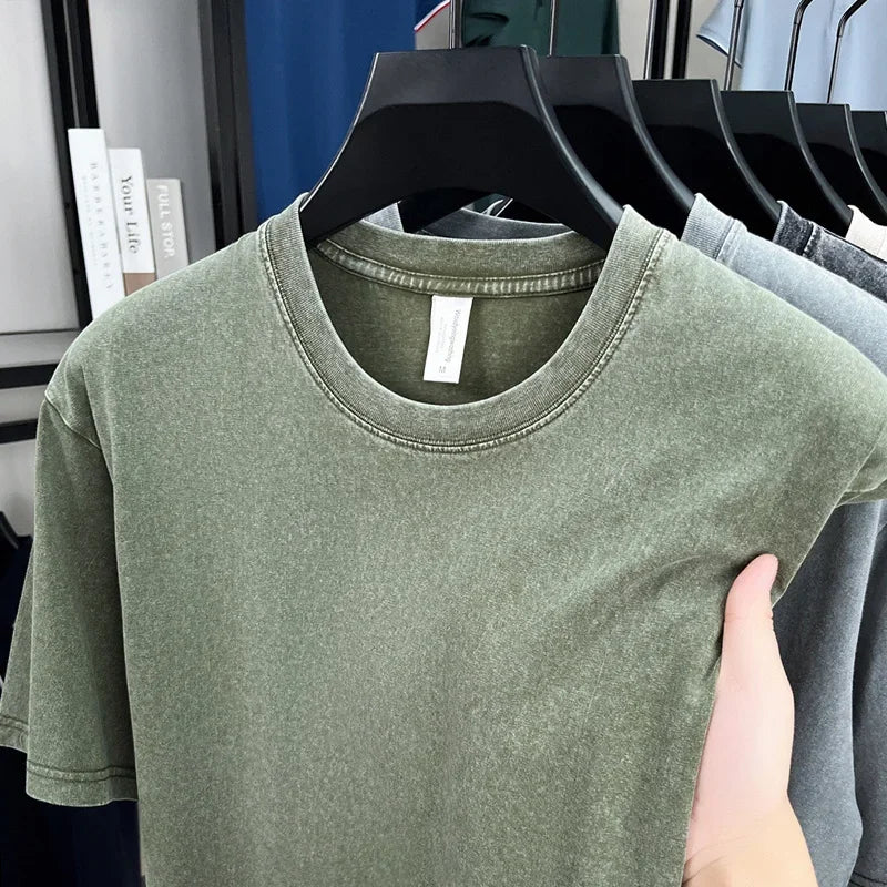 Green t-shirt on a hanger with a blurred background of other shirts and books.