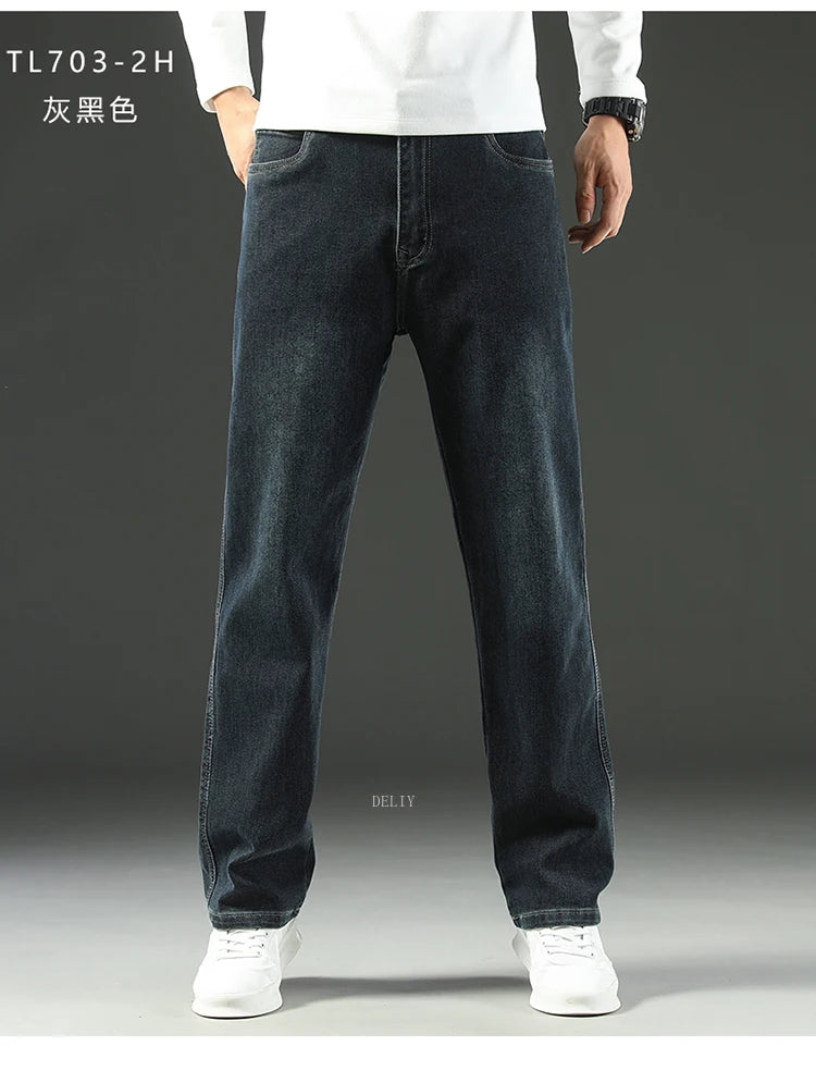 Person wearing dark blue jeans and white shoes on a gray background