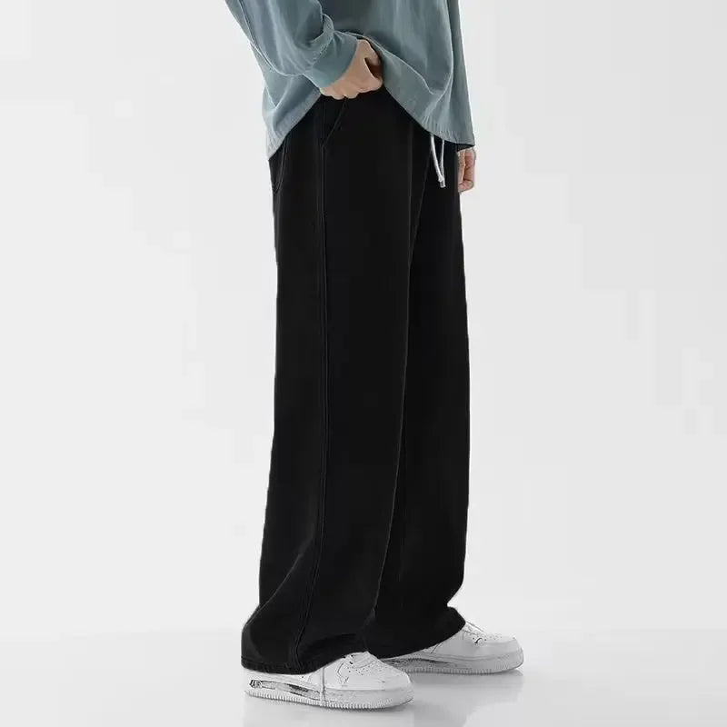 Person wearing black wide-leg pants and a light blue top on a white background