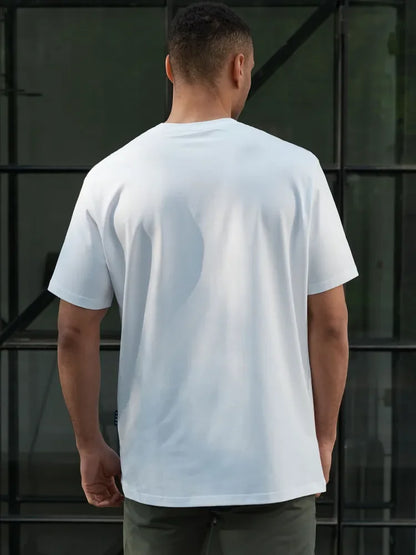 Person wearing a plain white t-shirt against a dark background