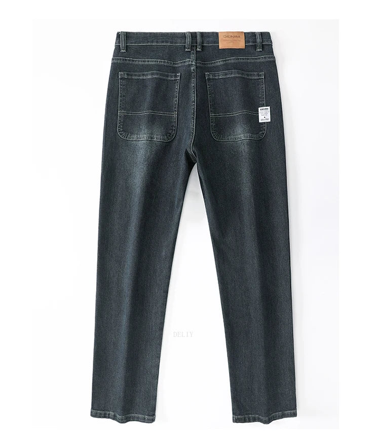 Back view of a pair of dark blue jeans on a white background