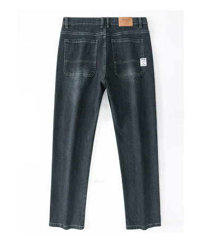Back view of a pair of dark blue jeans on a white background