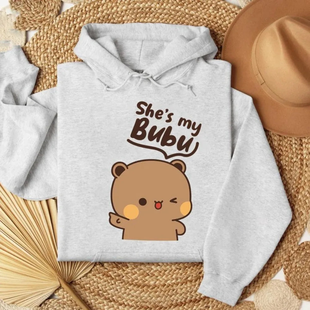 Gray hoodie with bear graphic and text 'She's my BUBU' on a woven surface.
