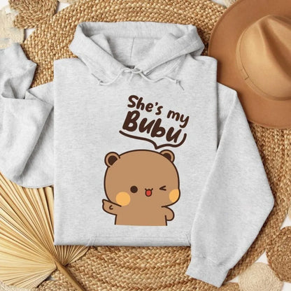 Gray hoodie with bear graphic and text 'She's my BUBU' on a woven surface.