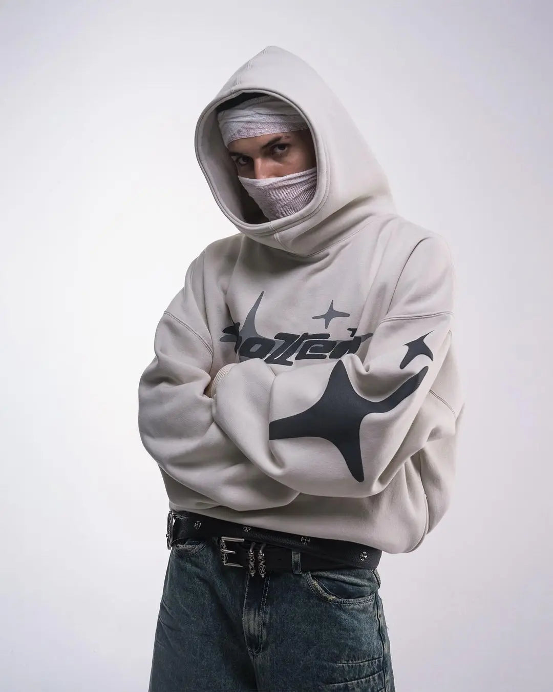 Person wearing a light gray hoodie with branding on a white background
